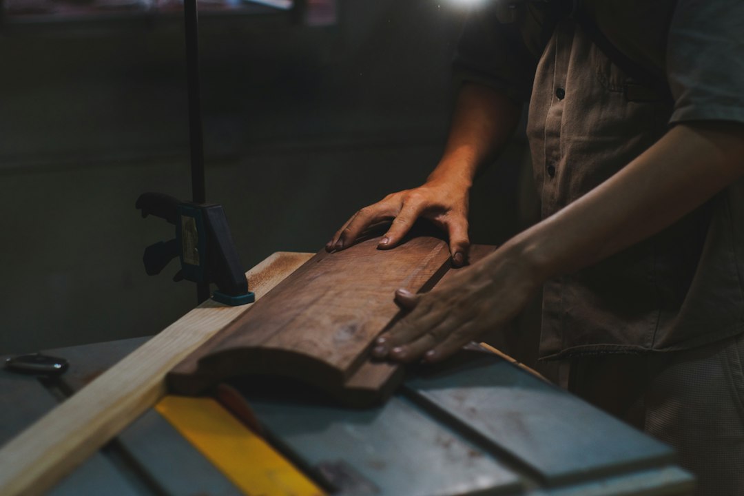 Cómo Fabricar una Mesa de Centro con Madera Maciza y Patas Metálicas: Carpenter's hands shaping wood on a table saw