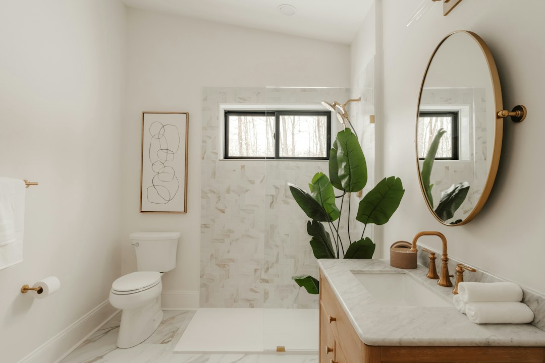 Cómo Sustituir una Baldosa o Azulejo Roto Sin Dañar el Revestimiento Contiguo: Modern bathroom with marble accents and a large plant