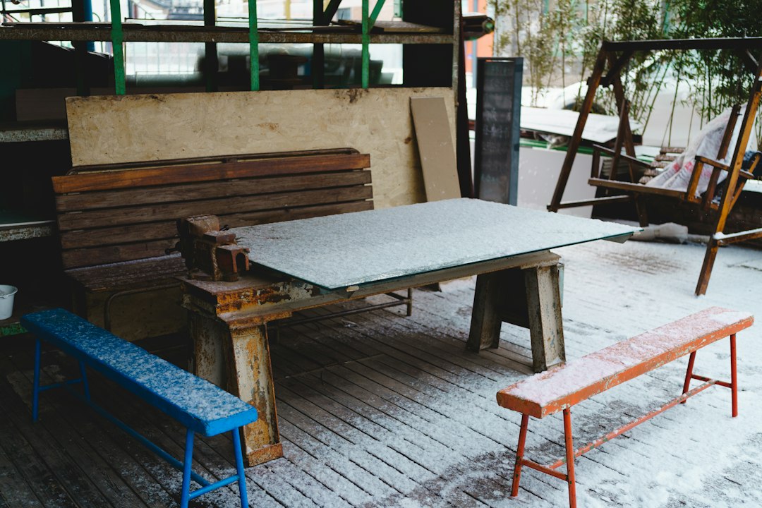Cómo Desatascar Tuberías y Sifones Domésticos de Forma Rápida y Segura: Snow-covered outdoor area with a table, benches, and a swing