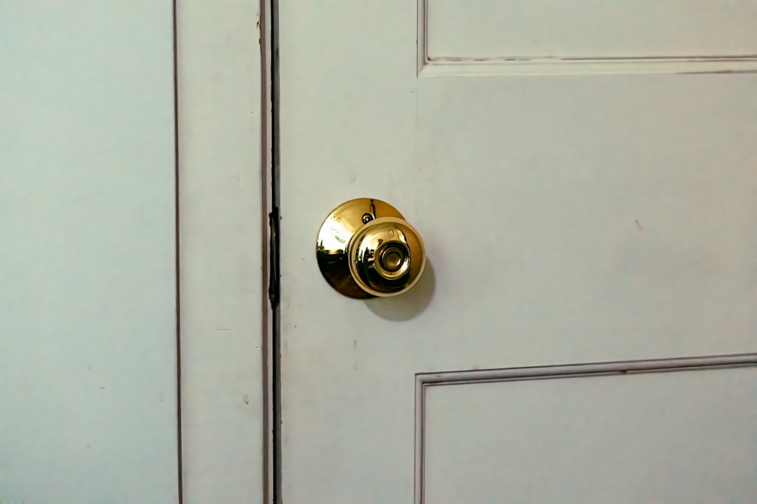 Cómo Ajustar las Bisagras de Cazoleta en Muebles de Cocina y Armarios: A close up of a door handle on a white door