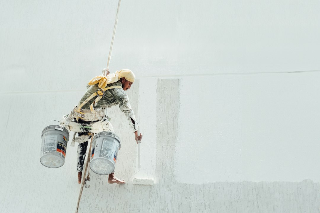 Guía para Instalar un Tabique de Pladur con Aislamiento Acústico: A painter is painting a white wall
