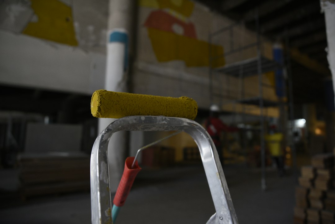 Cómo Reparar Grietas y Agujeros en Paredes de Yeso y Pintura con Masilla: a close up of a ladder with a yellow handle