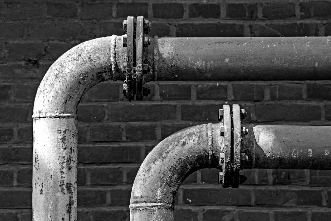 Cómo Reparar una Cisterna que Pierde Agua: Sustitución de Boyas y Mecanismos: a black and white photo of pipes on a brick wall