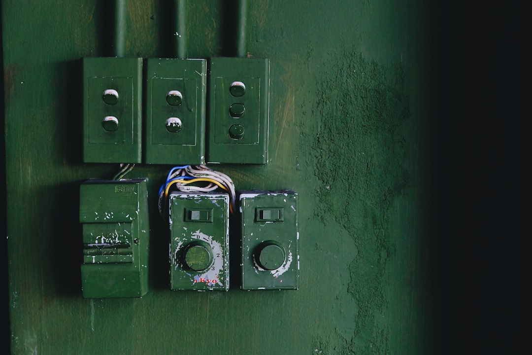 Cómo Cambiar un Enchufe o Mecanismo Eléctrico con Seguridad en Casa: a green wall with a couple of electrical boxes attached to it