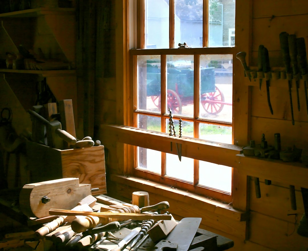 Guía para Cambiar el Bombín de una Cerradura y Aumentar la Seguridad: A wooden workbench with various hand tools in a sunlit workshop with a window